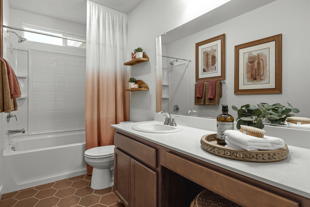 Extended vanity with solid-surface countertops and knee space at secondary bath